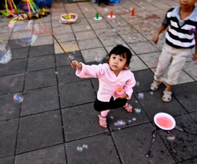 cute kids playing with bubble wands in Bukittinggi